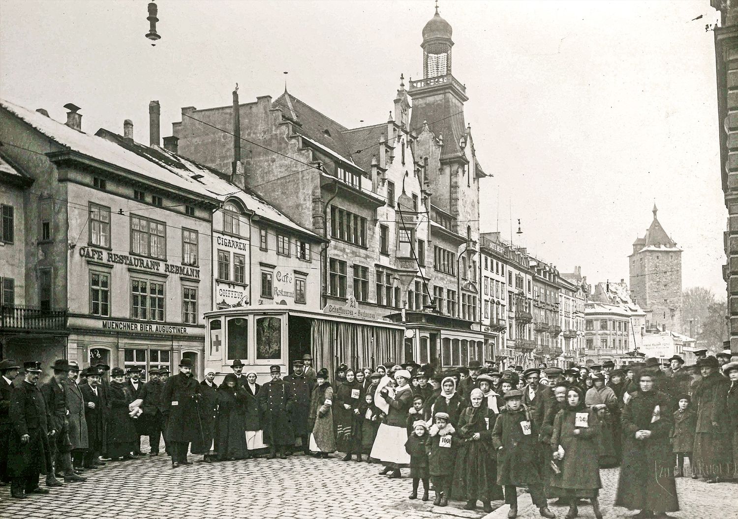 <time datetime="1917">1917</time>: Freiwillige des Heimschaffungsdienstes empfangen auf der Bahnhofstrasse französische und belgische Internierte. Die Ankommenden werden  versorgt und auf die Heimreise vorbereitet – eine beeindruckende Hilfsaktion der Schaffhauser Bevölkerung inmitten eigener Not.