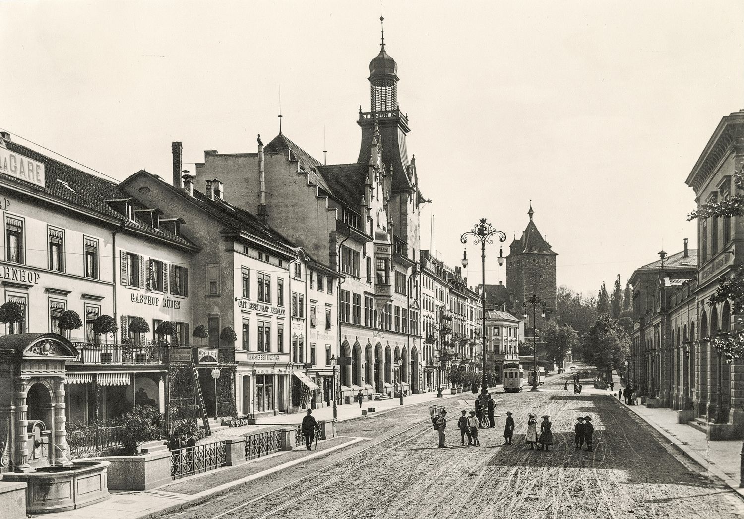 Eines der Hauptbilder der Ausstellung, das sogar einen Einfluss auf die heutige Gestaltung der Bahnhofstrasse hatte. Es zeigt die Bahnhofstrasse um <time datetime="1903">1903</time>. Dominant im Bild ist das Post- und Telegraphengebäude mit seinem alles überragenden Türmchen. Kleine Menschengruppen stehen in der Mitte der Bahnhofstrasse oder flanieren ihr entlang. Im Hintergrund sind zwei Tramwagen der neuen Strassenbahn nach Neuhausen am Rheinfall zu sehen. Die Bahnhofstrasse ist unbefestigt, im weichen Belag haben Pferdefuhrwerke ihre Karrenspuren hinterlassen. Ebendiese sind in der heutigen Gestaltung der Bahnhofstrasse wieder aufgenommen worden. In der Betonfahrbahn wurden «Karrenspurren» eingefräst – als Hommage an die Anfänge der Bahnhofstrasse.